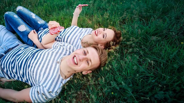 парень с девушкой лежат на траве